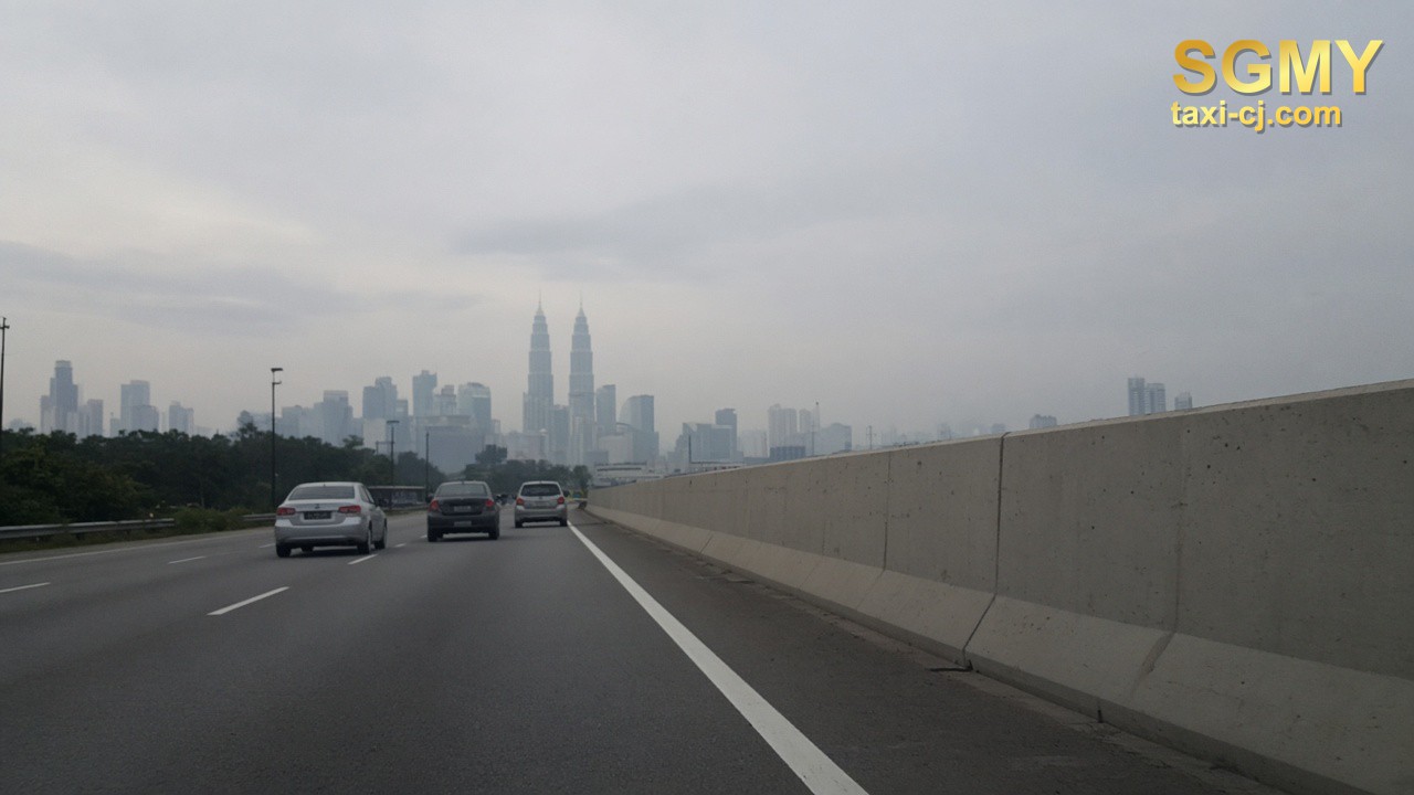 Kuala Lumpur towers in haze from a highway flyover