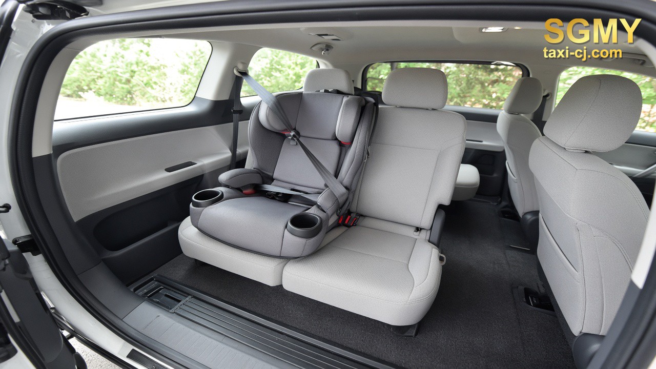 Empty child booster seat belted into a rear seat of an MPV